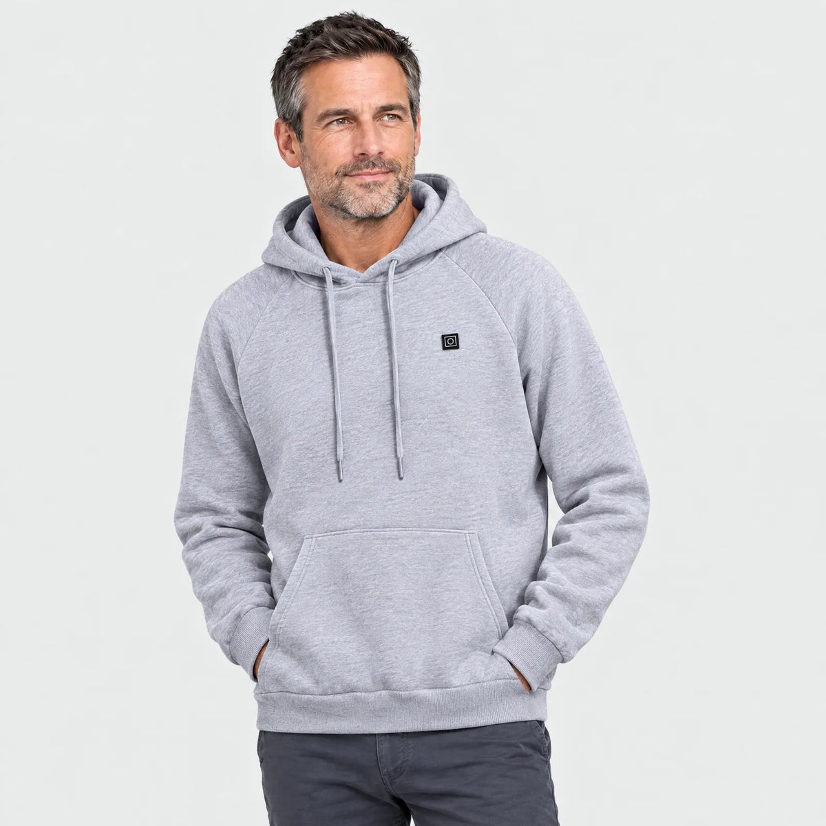 Mann im grauen beheizten Hoodie, Knopf für die Heizstufen auf der Brust